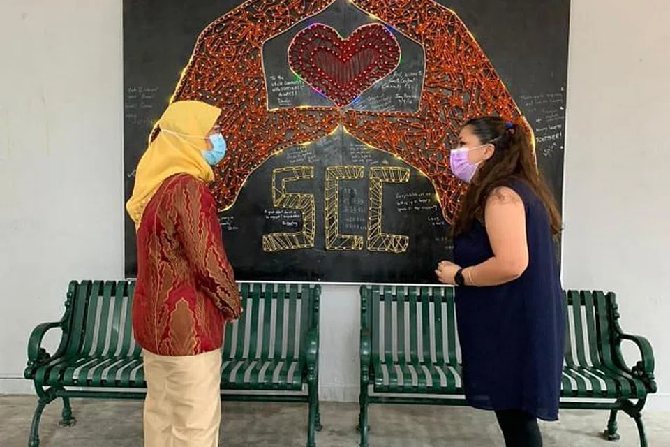 FAHAMI PERANAN PUSAT KHIDMAT KELUARGA: Presiden Halimah Yacob (kiri) berinteraksi dengan salah seorang sukarelawan Pusat Khidmat Keluarga Masyarakat South Central (SCC) yang terletak di Blok 5 Delta Avenue. - Foto BH oleh NUR FATHIN AWALLUDIN