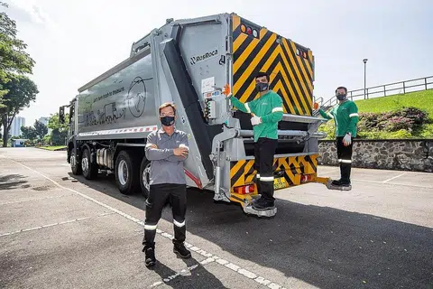 BERWAJAH BARU: (Dari kiri) Ketua Perkhidmatan SembWaste, Encik Lim Peng Soon; Duta Perkhidmatan SembWaste, Encik Satesh Kalimuthu dan Encik Mohamed Fahmi Azizi Mohd Zin, memakai pakaian seragam baru mereka sambil bergambar dengan lori pengumpulan sampah Mercedes-Benz baru yang digunakan di laluan pengumpulan sampah sektor Clementi-Bukit Merah mulai hari ini. - Foto SEMBWASTE
