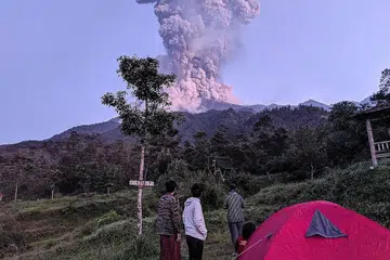 LEDAKAN SEIRING DEBU: Pelancong menyaksikan ledakan Gunung Merapi di daerah Cangkringan, Sleman, Yogyakarta, semalam. - Foto REUTERS