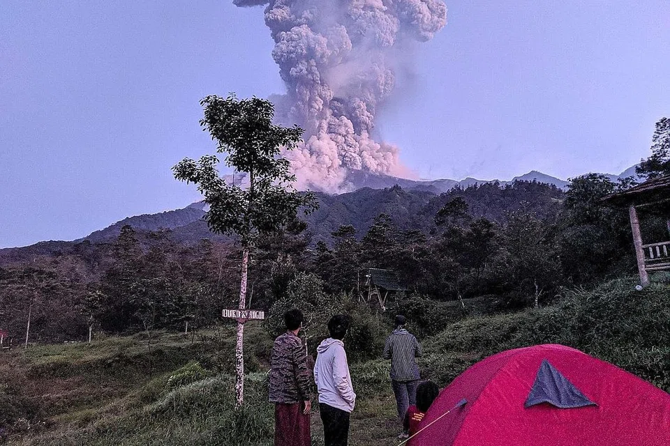 LEDAKAN SEIRING DEBU: Pelancong menyaksikan ledakan Gunung Merapi di daerah Cangkringan, Sleman, Yogyakarta, semalam. - Foto REUTERS