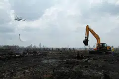 Gambar yang diambil pada 30 Ogos 2016 ini menunjukkan sebuah helikopter Badan Pengurusan Bencana Nasional (BNPB) Indonesia menjalankan misi pengeboman air bagi memadanmkan kebakaran di Kampar, Riau. 