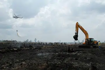 Gambar yang diambil pada 30 Ogos 2016 ini menunjukkan sebuah helikopter Badan Pengurusan Bencana Nasional (BNPB) Indonesia menjalankan misi pengeboman air bagi memadanmkan kebakaran di Kampar, Riau. 