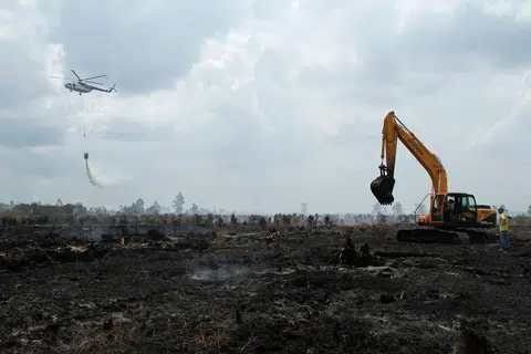 Gambar yang diambil pada 30 Ogos 2016 ini menunjukkan sebuah helikopter Badan Pengurusan Bencana Nasional (BNPB) Indonesia menjalankan misi pengeboman air bagi memadanmkan kebakaran di Kampar, Riau. 
