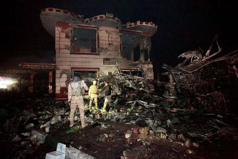 Pasukan keselamatan Iraq memeriksa tapak serangan bom trak bunuh diri, di sebuah kedai minyak di bandar Hilla, pada 24 Nov 2016. 