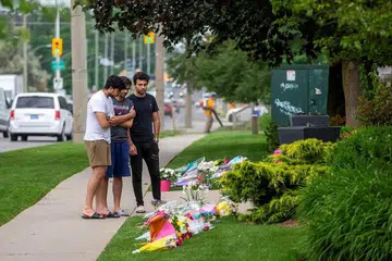 PENGHORMATAN TERAKHIR: Beberapa lelaki meninjau ruang peringatan sementara di masjid London Muslim Mosque yang letaknya sekitar 500 meter daripada tempat di mana seorang pemuda diberkas kerana disyaki menyerang keluarga Islam hingga maut di London, Ontario, Canada. - Foto REUTERS/CARLOS OSORIO 