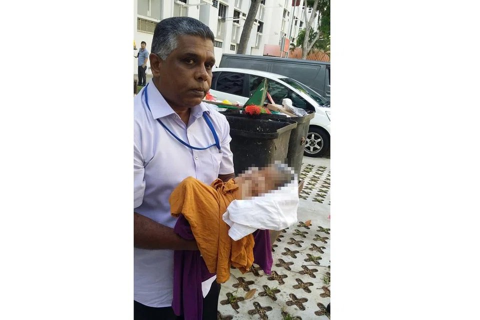 BAYI DITEMUI DALAM TONG SAMPAH: Encik Patwarishamin menemui bayi sedang menangis di dalam beg plastik sewaktu mengosongkan tong sampah. - Foto THE STRAITS TIMES