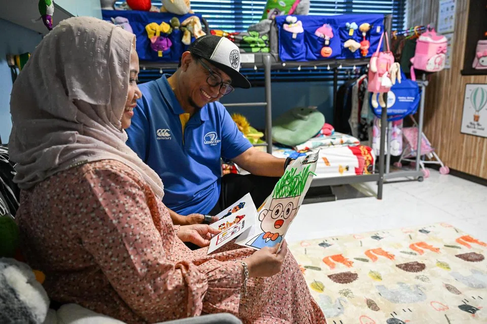 Ibu bapa titipan Cik Zaina Zainal, 48 tahun, dan Encik Mohammad Asiek Ashari, 45 tahun, membelek lukisan anak-anak titipan mereka.