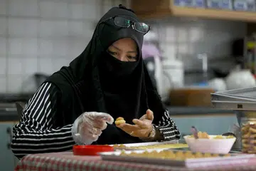 USAHAKAN PENDAPATAN DARI SUMBER LAIN: Untuk menambah pendapatan keluarga, Cik Sulasteri Muslim mengambil tempahan kuih tart dan boleh menghasilkan sekitar 14 botol kuih tart dalam sehari. Foto BH oleh JOEL CHAN