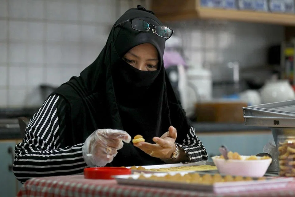 USAHAKAN PENDAPATAN DARI SUMBER LAIN: Untuk menambah pendapatan keluarga, Cik Sulasteri Muslim mengambil tempahan kuih tart dan boleh menghasilkan sekitar 14 botol kuih tart dalam sehari. Foto BH oleh JOEL CHAN