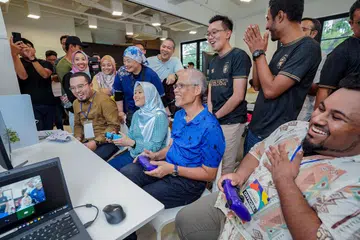 BERAMAH MESRA: (Duduk, dari kiri) Pengerusi penganjur Pesta Belia M Kuasa Tiga (M³), Encik Ahmad Muhsein Jasmani; Setiausaha Parlimen Kanan (Kesihatan merangkap Undang–Undang), Cik Rahayu Mahzam; dan Menteri Bertanggungjawab bagi Ehwal Masyarakat Islam, Encik Masagos Zulkifli Masagos Mohamad, bermain permainan e-sukan Fifa bersama belia di Pesta Belia M³ 2023 pada Ahad.