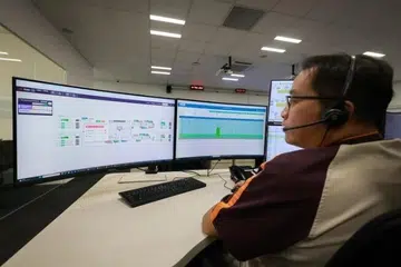 Pengawal perkhidmatan kanan SBS Transit, Encik Calvin Chan, meneliti cadangan yang diberikan oleh FlowOS Live, sistem perisian kawalan dan operasi bas yang dikuasakan oleh kecerdasan buatan (AI), di Depoh Bas Seletar.
