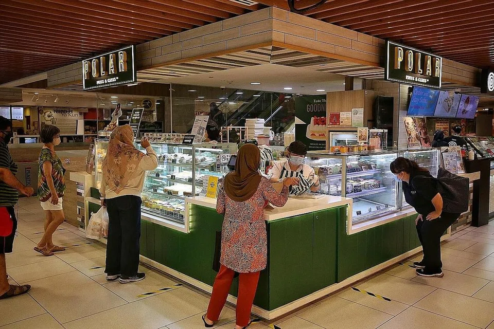 PASTIKAN JARAK SELAMAT: Pelanggan memastikan jarak selamat ketika membeli makanan di Polar Puffs and Cakes di pusat beli-belah White Sands semalam. - Foto BH oleh KEVIN LIM