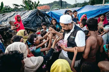 PAPARKAN SEMANGAT DERMAWAN: Pengurus projek dan pengumpulan dana Global Ehsan Relief, Ustaz Muhammad Faisal Mohamed Ayub, dalam satu projek mengagih bantuan. - Foto GLOBAL EHSAN RELIEF
