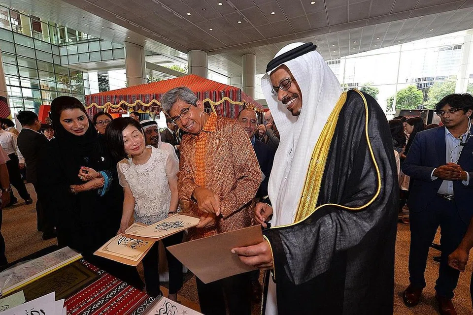 LIHAT KALIGRAFI ARAB: (Dari kiri) Cik Elaine Ng, Dr Yaacob Ibrahim dan Dr Mohamed Omar A. Balfaqeeh mengunjungi sebuah pameran yang menunjukkan seni kaligrafi tulisan Arab di Pameran Hari Budaya UAE semalam. - Foto KEDUTAAN UAE