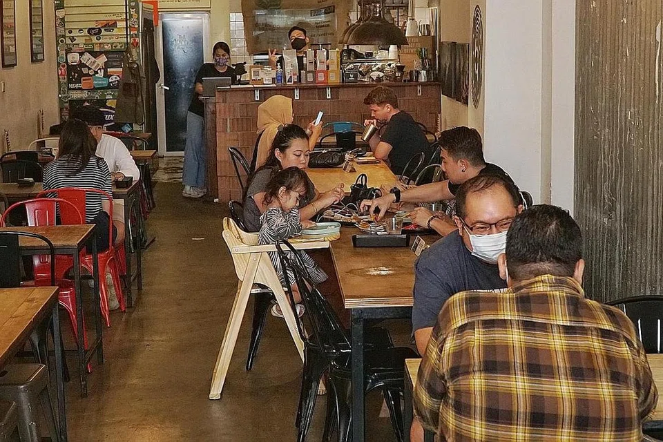 HELA NAFAS LEGA: Lebih ramai pelanggan kelihatan di Working Title: The Burger Bar yang bernaung di bawah Black Hole Group. Pengurus kanannya, Encik Afiq Sulaiman, berkata rangkaian kafe tersebut melihat peningkatan pada jumlah tempahan yang dibuat sebaik kelonggaran makan di luar diumumkan. - Foto BH oleh KHALID BABA