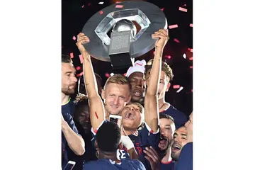 JULANG PIALA: Bintang muda Monaco, Kylian Mbappe, menjulang trofi kejuaraan Ligue 1 Perancis di Stadium Louis II dinihari semalam. - Foto AFP