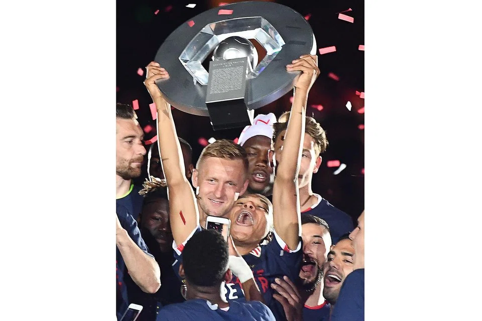 JULANG PIALA: Bintang muda Monaco, Kylian Mbappe, menjulang trofi kejuaraan Ligue 1 Perancis di Stadium Louis II dinihari semalam. - Foto AFP