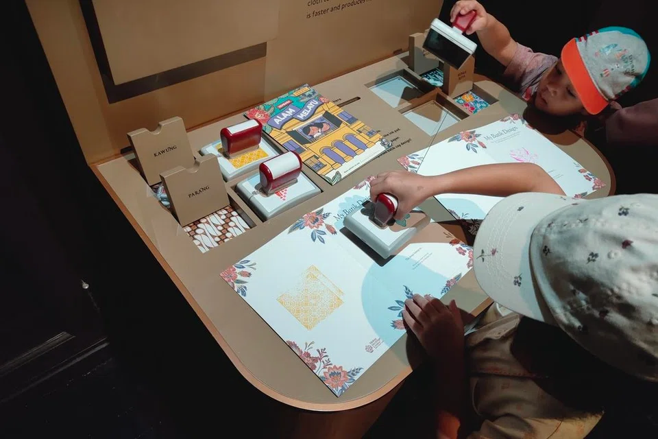 Pengunjung cilik boleh menggunakan empat cap berlainan corak dan warna yang disediakan untuk menghiasi buku kecil, ‘My Batik Design’ (Rekaan Batik Saya), yang boleh diambil di ruang itu juga.