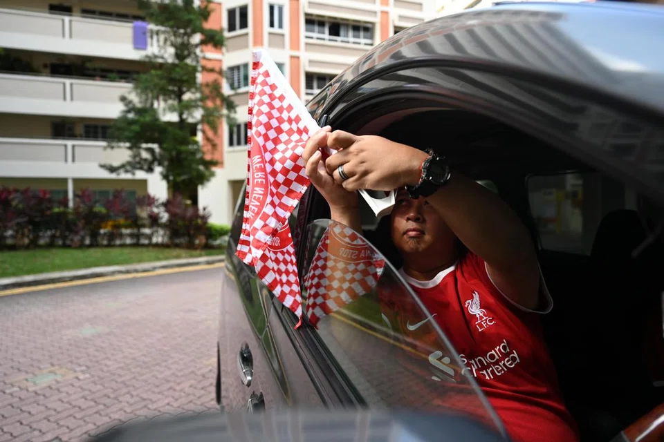 PERJALANAN MERIAH: Encik Mohammad Muhaimin memasang bendera di tingkap keretanya. “Kita mesti datang dengan gaya yang hebat!” kata beliau dengan megah. 