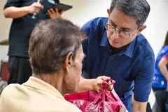 Dr Muhammad Faishal Ibrahim memberikan habuan Raya kepada Ahmad (bukan nama sebenar) semasa majlis buka puasa di Rumah Peralihan Selarang.
