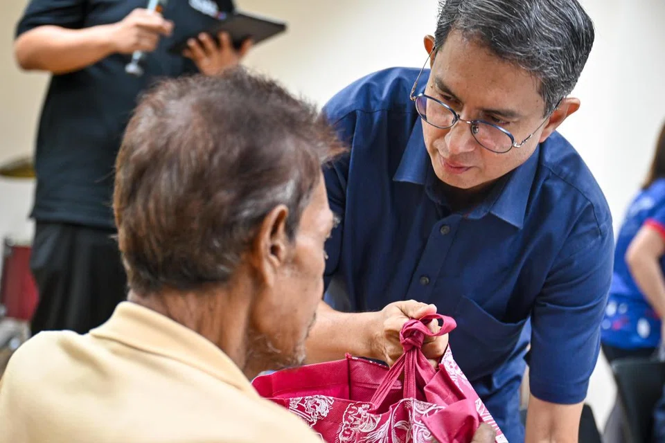 Dr Muhammad Faishal Ibrahim memberikan habuan Raya kepada Ahmad (bukan nama sebenar) semasa majlis buka puasa di Rumah Peralihan Selarang.