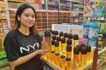BUKAN BOTOL 'BIASA': Reka bentuk botol Cik Dini terpilih dan kini digunakan Heng Teng Foh Medicall Hall untuk menjual produk teh herba mereka. - Foto NYP