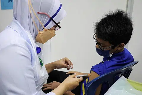 VAKSINASI BAGI GOLONGAN REMAJA: Seorang pelajar sekolah menengah menerima vaksinasi Covid-19 di sebuah sekolah di Putrajaya baru-baru ini. - Foto REUTERS