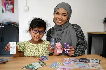Pengasas Qararmel by Fitriadeluna, Cik Nur Fitria Saaban, menghasikan sampul Raya comel, seperti yang berbentuk gula-gula, bagi mencuit hati kanak-kanak. 