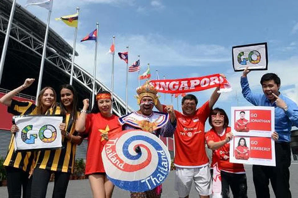 JALIN HUBUNGAN: Pasukan kegemaran masing-masing bertarung di gelanggang, tetapi penyokong mereka yang datang dari berbilang negara menjalin hubungan baik semasa memberi sokongan. - Foto THE STRAITS TIMES 