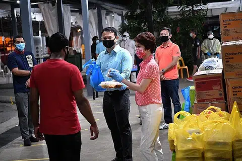 AGIH SAHUR: Encik Zaqy Mohamad (tiga dari kiri) dan Cik Low Yen Ling (empat dari kiri) membantu mengagihkan makanan bersahur untuk pekerja Muslim di dormitori PPT Lodge 1A, di Punggol dinihari semalam. - Foto BH oleh ARIFFIN JAMAR
