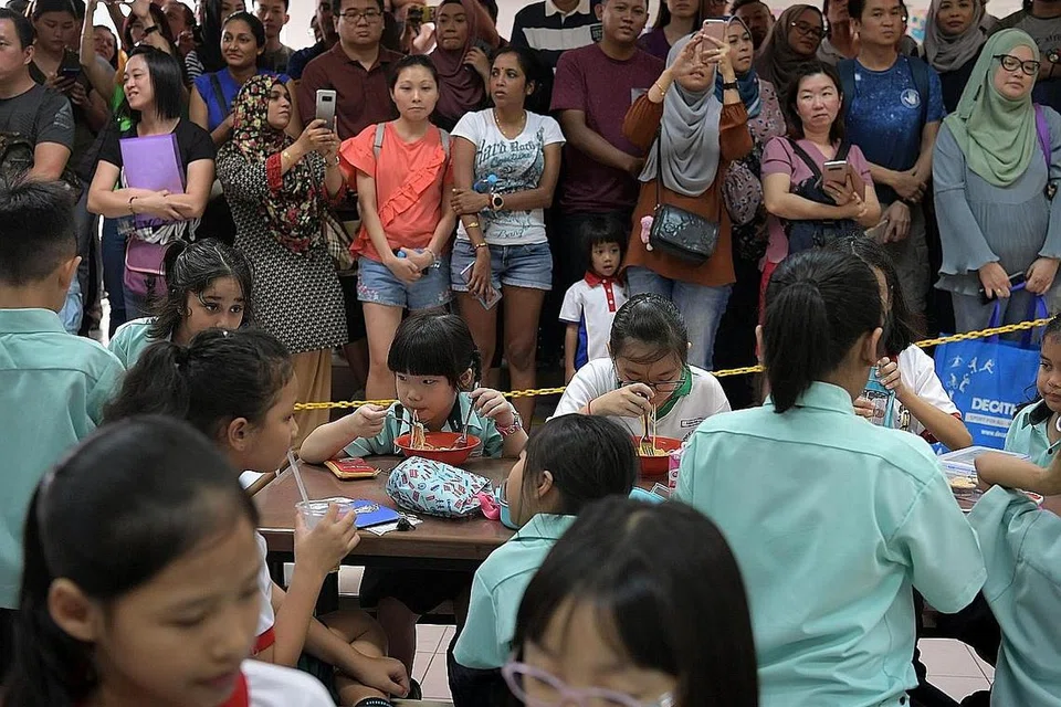 TAHUN BARU, SEKOLAH BARU: Pelajar darjah satu di Sekolah Rendah Huamin semasa waktu rehat di kantin sementara diperhatikan ibu bapa mereka dari jauh. - Foto BH oleh NG SOR LUAN