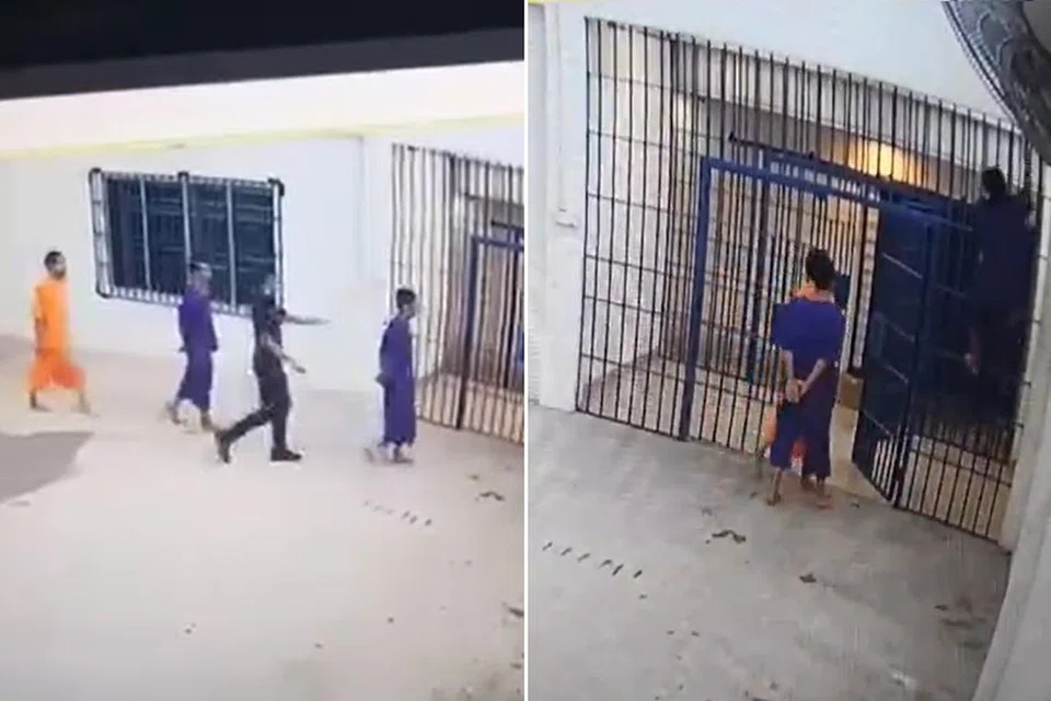 PANJAT JERIJI: Seorang tahanan (paling kanan) kelihatan memanjar jeriji semasa pegawai lokap sedang membuka pintu.