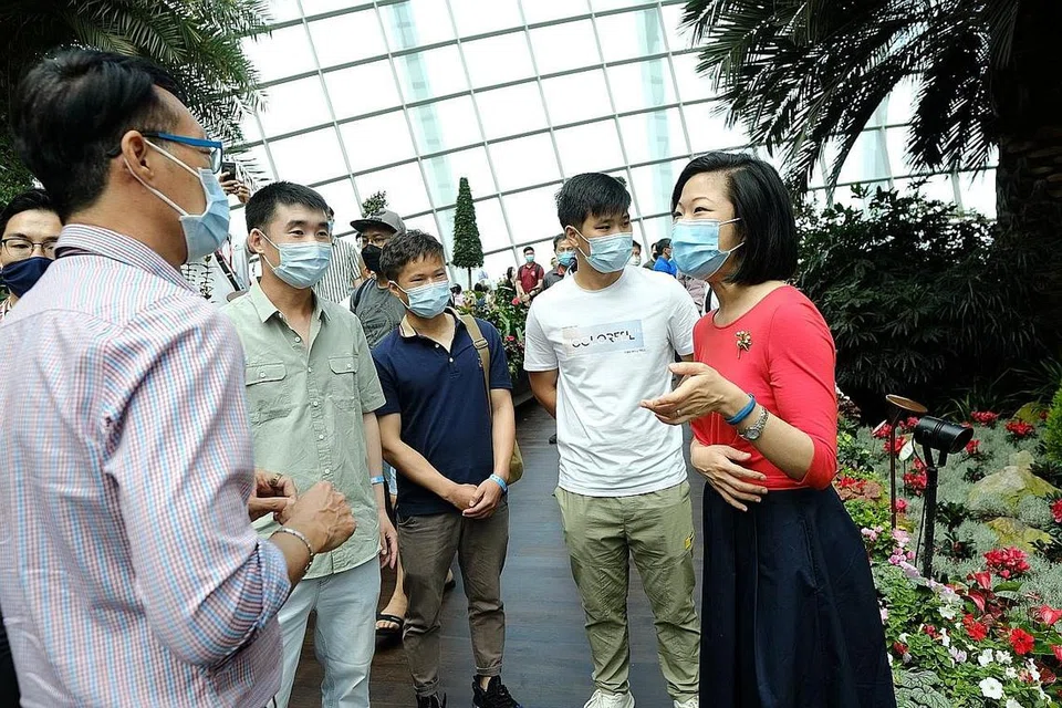 LAWATAN GARDENS BY THE BAY: Menteri Negara Kanan, Kementerian Ehwal Luar & Kementerian Pembangunan Negara, Cik Sim Ann (kiri) bersama pekerja migran China di Gardens by the Bay sempena Hari Pekerja Migran Antarabangsa. - Foto