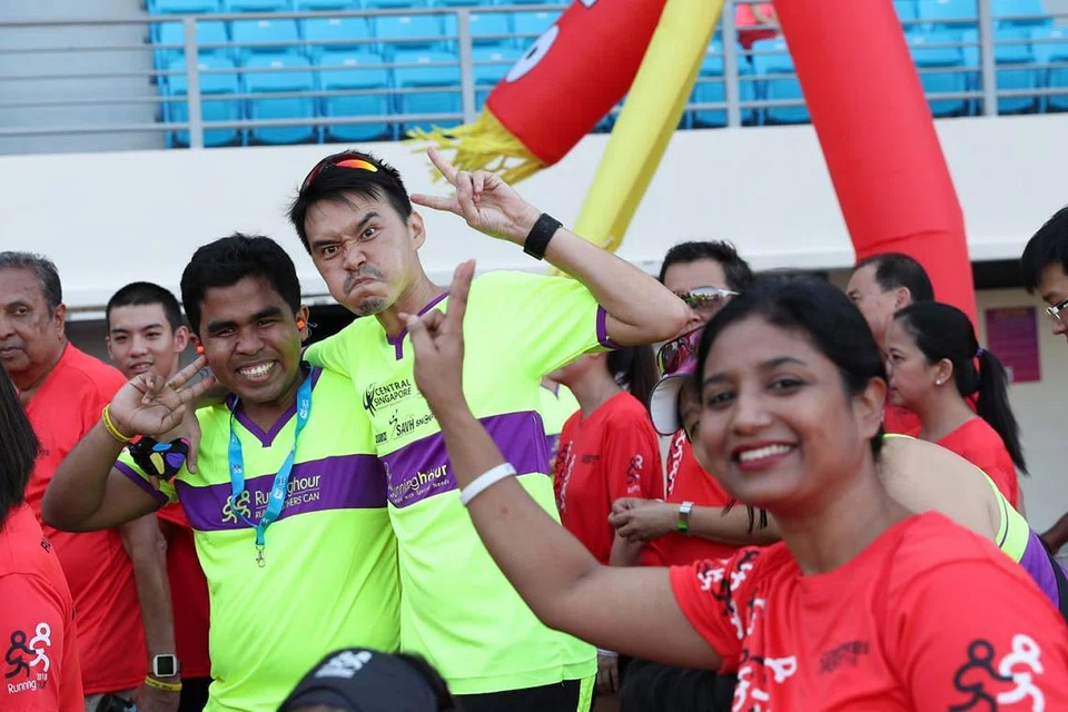 BINA KEYAKINAN: Mohamed Firdaus Mohamed Ismail (kiri berbaju kuning) seronok menyertai larian ditemani sukarelawan Encik Kelvin Tan Kwee Hong (kanan), yang membantunya hingga ke akhir garisan dalam larian bersepadu, Run For Inclusion 2018. - Foto BH oleh TIMOTHY DAVID