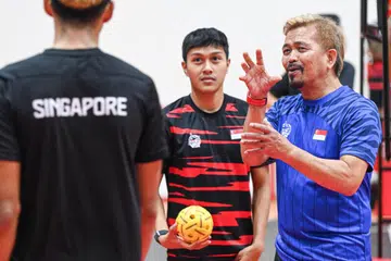 Ketua jurulatih pasukan nasional sepak takraw lelaki Singapura, Salleh Nanang (kanan), memberi arahan kepada pemain semasa satu sesi latihan di Heartbeat@Bedok pada 26 Ogos.