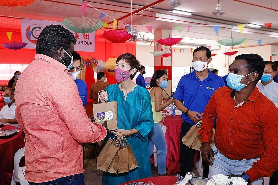 BERAMAH-TAMAH: Menteri Tenaga Manusia Josephine Teo memeriahkan suasana sambutan Deepavali dengan mengedarkan bungkusan cemil-cemilan dan manisan kepada pekerja asing di sebuah dormitori Sungei Kadut semalam. - Foto MOM