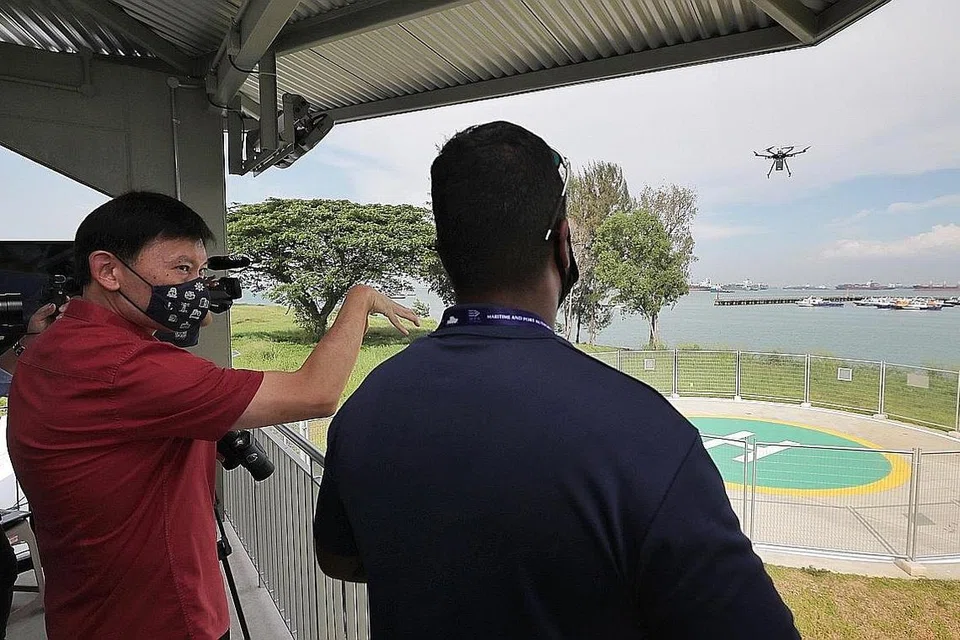 JIMAT MASA DAN TENAGA: Menteri Negara Kanan (Ehwal Luar merangkap Pengangkutan) Chee Hong Tat (kiri) berada di Estet Dron Maritim berdekatan Marina South Pier menyaksikan bagaimana dron berlepas dengan membawa pakej untuk dihantar ke kapal yang berlabuh di tengah laut. - Foto BH oleh GAVIN FOO