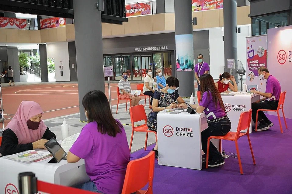 RAIH KEMAHIRAN: Cik Norjah Samdin (kiri) menimba kemahiran digital daripada Duta Digital seperti Cik Nur Shahana Esha (dua dari kiri) di Hab Masyarakat SG Digital di Kelab Masyarakat Jurong Spring. - Foto BH oleh ONG WEE JIN