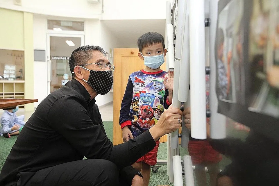 GALAK KANAK-KANAK KE PRASEKOLAH: Dr Maliki berinteraksi bersama seorang murid semasa lawatannya ke Pusat Penjagaan Kanak-Kanak Besar Punggol E-Bridge semalam. - Foto KEMENTERIAN PENDIDIKAN