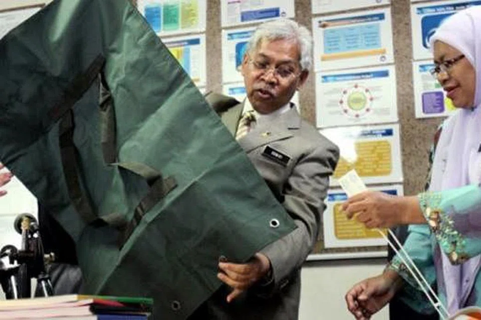 KARUNG BERISI KERTAS PEPERIKSAAN: Datuk Seri Idris dan Pengarah Lembaga Peperiksaan Malaysia, Dr Nai'mah Ishak, menunjukkan karung yang digunakan untuk mengisi kertas soalan UPSR pada sidang media di Kementerian Pendidikan semalam. - Foto THE STAR