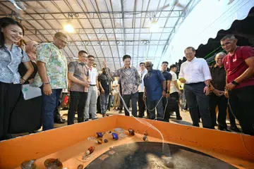 Perdana Menteri, Encik Lawrence Wong (tengah, berbaju batik), bermain gasing di Pesta Jalur 2024 di Wisma Geylang Serai sempena pelancaran Gerbang Ikonik pada 7 September. Bersamanya ialah Menteri di Pejabat Perdana Menteri merangkap Menteri Kedua (Pendidikan dan Ehwal Luar), Dr Mohamad Maliki Osman (tiga dari kiri), yang juga pengerusi Jawatankuasa Jalur Budaya Geylang Serai; Menteri Tenaga Manusia, Dr Tan See Leng (tiga dari kanan); dan Menteri Bertanggungjawab bagi Ehwal Masyarakat Islam, Encik Masagos Zulkifli Masagos Mohamad (dua dari kanan).