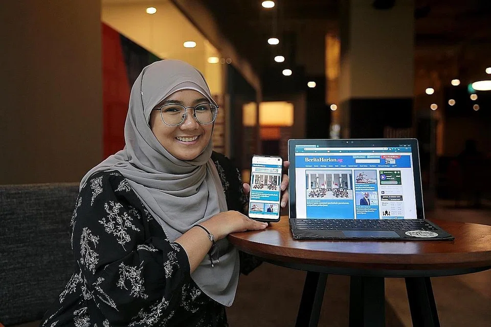 BERITA DIGITAL: Cik Juzanvina (kiri) lebih gemar membaca berita menerusi wadah digital di telefon bimbit atau komputer riba beliau. - Foto BM oleh JASON QUAH