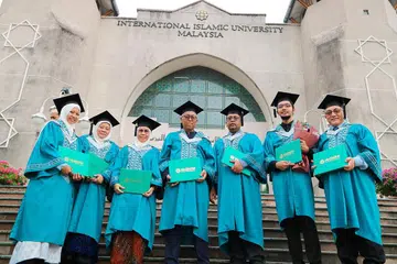 TERCAPAI CITA-CITA: Cik Farida Othman (tiga dari kiri) dan suaminya, Encik Sumartono Rono Pawiro (empat dari kiri), bergambar kenangan selepas tamat Majlis Konvokesyen di Universiti Islam Antarabangsa Malaysia (IIUM) pada Ogos lalu. - Foto PERGAS