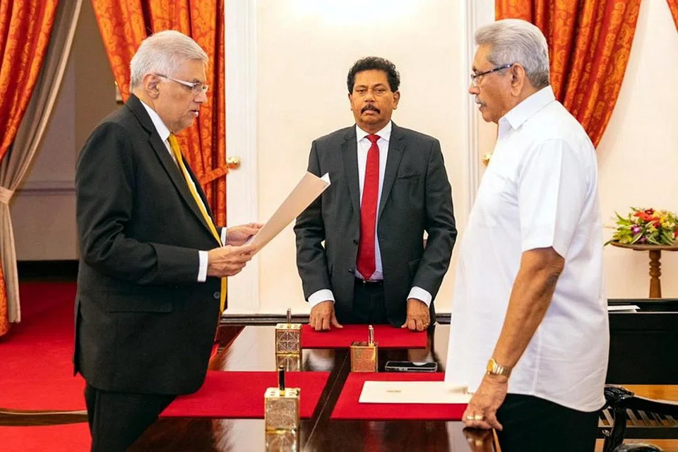 PERDANA MENTERI KALI KEENAM: Pemimpin Parti Perpaduan Nasional, Encik Ranil Wickremesinghe (kiri) mengangkat sumpah di hadapan Presiden Gotabaya Rajapaksa dalam satu majlis di pejabat presiden kelmarin. - Foto EPA-EFE