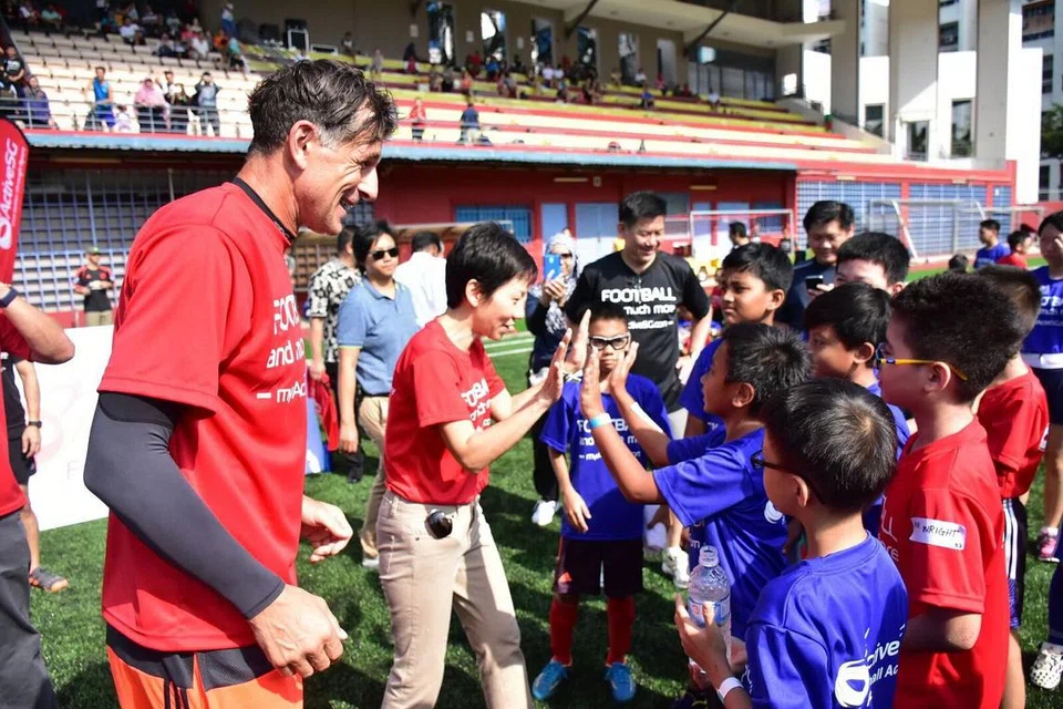 BUKA PELUANG: Duric (kiri) dan Cik Fu (dua dari kiri) beramah mesra dengan peserta bengkel bola sepak cilik di Stadium Jurong East semalam.