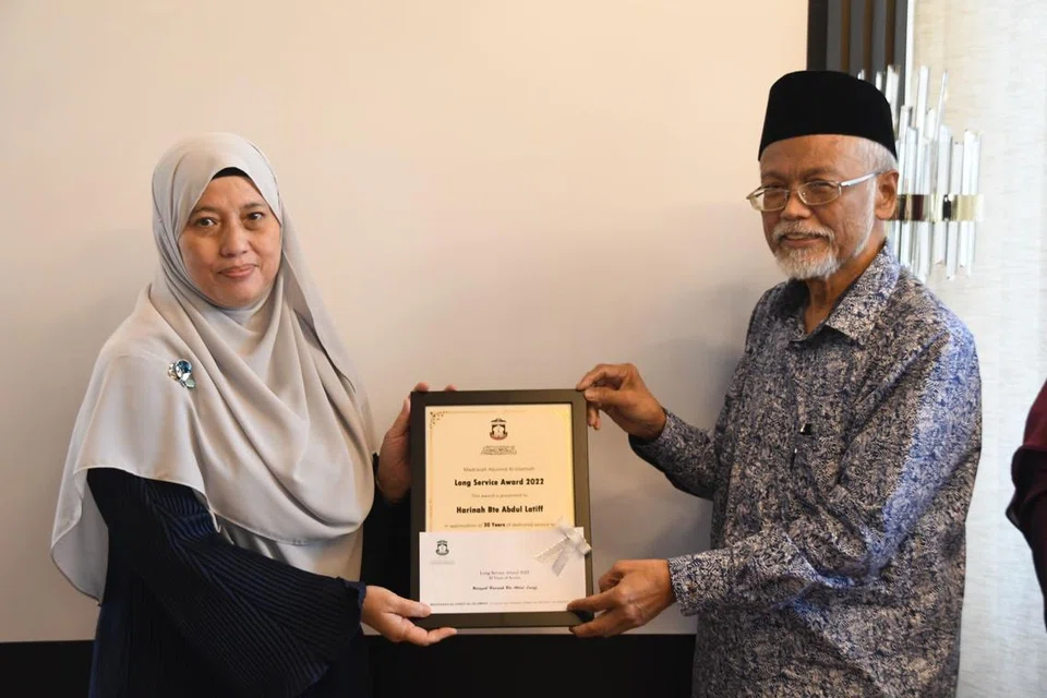 Ustazah Harinah Abdul Latiff menerima Anugerah Khidmat Setia pada 2022 setelah bertugas selama 30 tahun di Madrasah Aljunied Al-Islamiah. Anugerah disampaikan oleh Ustaz Pasuni Maulan.