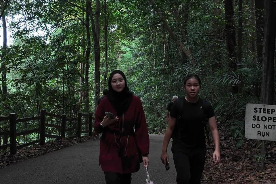 Wartawan pelatih, Aishah Effandy (kiri), dan Nahwah Aidilreza, melakukan pendakian setinggi 70 meter di Hutan Simpanan Bukit Timah menyerupai pendakian Jabal Rahmah di Arafah.
