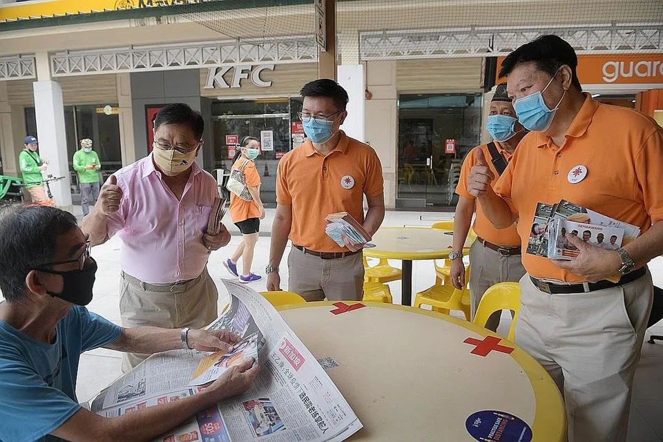 DEKATI PENDUDUK: Calon Parti Perpaduan Nasional (NSP) bagi Sembawang GRC, Encik Spencer Ng (tiga dari kiri), Encik Yadzeth Hairis (empat dari kiri) dan Encik Sebastian Teo (kanan) bertemu penduduk di Woodlands semalam. Mereka bersaing dengan pasukan PAP di sana yang diketuai Menteri Pendidikan Encik Ong Ye Kung. - Foto BH oleh ALPHONSUS CHERN