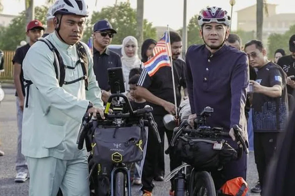 Pelakon Amar Baharin (kanan) bersama sahabatnya, Datuk Muhamad Muqharabbin Mokhtarrudin berlepas dari Padang Besar, Kedah pada pagi Ahad dalam jalani kembara basikal tiga bulan ke Arab Saudi.