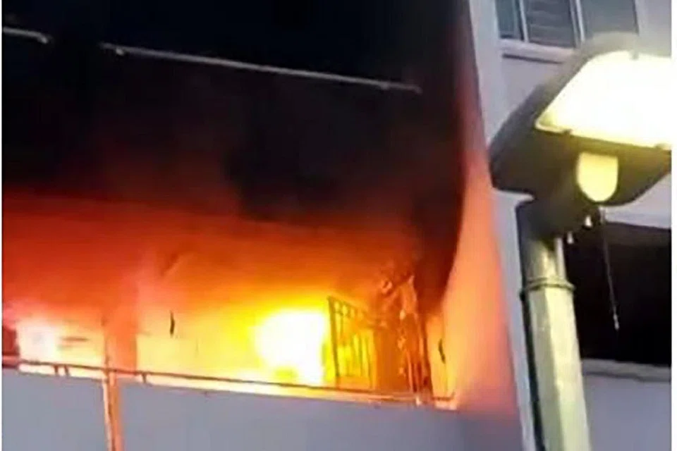 KEBAKARAN MEMBAWA MAUT: Gambar atas menunjukkan api yang marak di unit itu. - Foto FACEBOOK SCDF, ST ONLINE